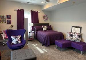 a bedroom with a purple bed and a chair at VIP Suites for Business Women, Nurses, College Moms Traveling to Indianapolis in Indianapolis