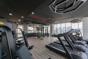 a gym with treadmills and elliptical machines at Spacious 3BR Apartment Near Miracle Garden in Dubai