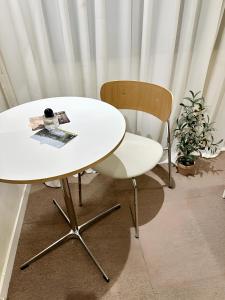 a white table and a chair in a room at SSH Ikseon peter cat Hostel in Seoul