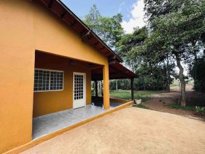 un edificio amarillo con garaje con puerta blanca en Casa Amarela - Aconchegante e Familiar en Alto Paraíso de Goiás