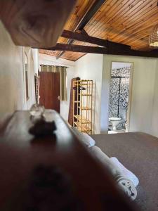 um quarto com uma cama e vista para uma casa de banho em Casa Amarela - Aconchegante e Familiar em Alto Paraíso de Goiás