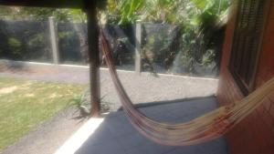 uma rede sentada fora de uma casa em Casa da Felicidade em Tramandaí