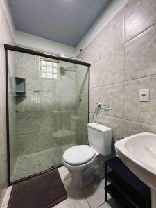 a bathroom with a shower and a toilet and a sink at Casa Amarela - Aconchegante e Familiar in Alto Paraíso de Goiás