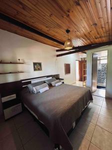 um quarto com uma cama grande e um tecto em madeira em Casa Amarela - Aconchegante e Familiar em Alto Paraíso de Goiás