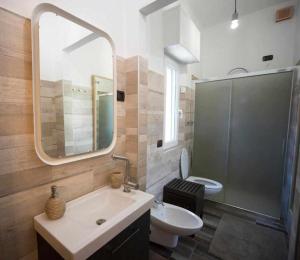 een badkamer met een wastafel, een toilet en een spiegel bij CasAlfredo Appartamento in Santa Croce sullʼ Arno