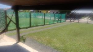 uma vista para uma cerca com um campo de relva em Casa da Felicidade em Tramandaí