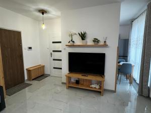 sala de estar con TV de pantalla plana en la pared en Apartament Moderato en Starogard Gdański