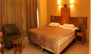 um quarto de hotel com uma cama e uma cadeira em FabHotel Prime Orchard Hospitality em Pune