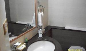 bagno con lavandino e specchio di FabHotel Prime Orchard Hospitality a Pune