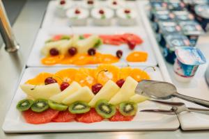 a plate of fruit on a table with a spoon at DoubleTree by Hilton Hotel Cluj - City Plaza in Cluj-Napoca