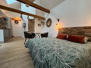 Un dormitorio con una cama grande y una mesa. en La Grange de Marcel, en Saint-Pol-de-Léon