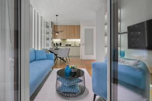 a living room with blue couches and a table at Melody Apartment in Novi Beograd