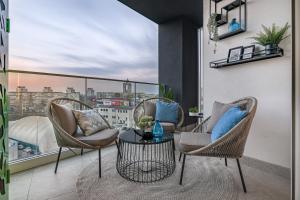 a balcony with chairs and a table with a view at Melody Apartment in Novi Beograd