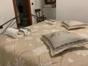 uma cama com toalhas e almofadas em cima em Sa Prenda em Nuoro