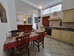 uma cozinha com uma mesa com cadeiras e um balcão em Sa Prenda em Nuoro