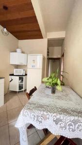 a kitchen with a table with a plant on it at Chalés em Ilhabela in Ilhabela