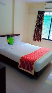 Un dormitorio con una cama grande con una manta roja. en Nobel Studio, en Pune