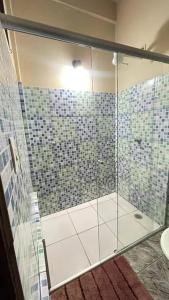 a bathroom with a shower with blue and green tiles at Chalés em Ilhabela in Ilhabela +31 photos
