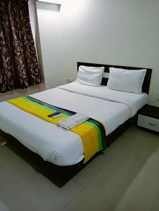 Una cama blanca grande con una manta colorida. en Nobel Studio, en Pune