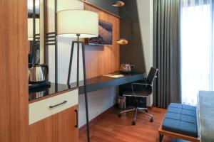 a desk with a lamp and a chair in a room at Expoist Hotel in Beylikduzu