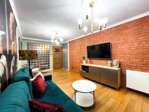 a living room with a couch and a brick wall at Apartament przy Głównym Rynku in Kościerzyna