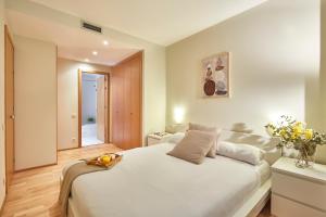 1 dormitorio con 1 cama blanca grande en una habitación en BBarcelona Plaça Universitat Flat, en Barcelona