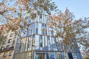 un edificio di vetro con alberi di fronte di BBarcelona Plaça Universitat Flat a Barcellona