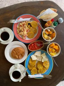 una mesa con platos de comida y tazas de café en Eco Hotel Bosque Encantado, en Isla Grande