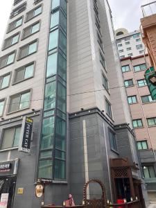 ein hohes Gebäude mit Glasfenstern auf einer Stadtstraße in der Unterkunft SSH Ikseon peter cat Hostel in Seoul