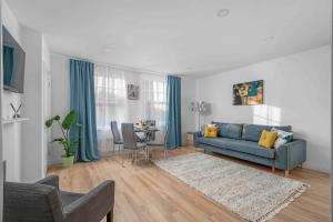 a living room with a blue couch and a table at Brick Lane, London - Lovely One Bedroom Apartment in London