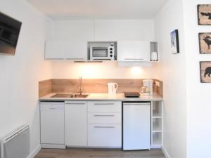 cocina blanca con fregadero y microondas en Appartement Montgenèvre, 2 pièces, 4 personnes - FR-1-266-107 en Montgenèvre