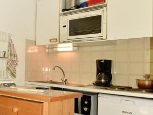 eine Küche mit einer Spüle und einer Mikrowelle in der Unterkunft Studio Montgenèvre, 1 pièce, 4 personnes - FR-1-266-130 in Montgenèvre