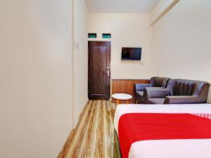een hotelkamer met een bed en een bank bij OYO 92871 Ciparay Residence in Bandung