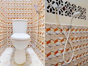 een badkamer met een toilet en een mozaïekmuur bij OYO 92871 Ciparay Residence in Bandung