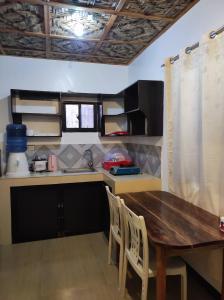 a kitchen with a wooden table and chairs at Hidden Gem Siargao in General Luna
