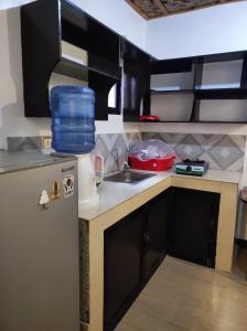 a small kitchen with a refrigerator and a sink at Hidden Gem Siargao in General Luna