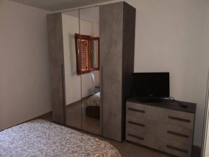 - une chambre avec une grande armoire en bois et une télévision dans l'établissement Appartamento Il Conforto, à Monte Marcello