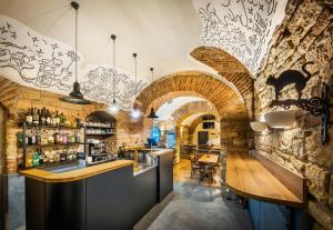 eine Bar in einem Restaurant mit einer Steinmauer in der Unterkunft Martin Hotel Prague in Prag