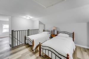 two beds in a room with white walls and wood floors at Updated Minersville Townhome by ATV Trail! in Mount Pleasant