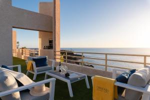 einen Balkon mit Stühlen, einem Tisch und Meerblick in der Unterkunft OBSIDIAN Mirador del Oceano in Puerto de Santiago