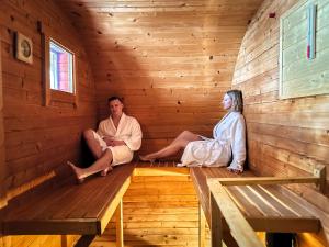 a man and woman sitting in a sauna at Hotel Kamzík *** in Malá Morávka