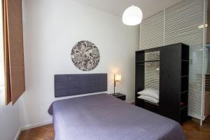 1 dormitorio con cama y espejo en la pared en COPACABANA - Lindo apartamento na quadra da praia, en Río de Janeiro