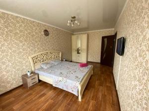 a bedroom with a bed with a pink pillow on it at 1 комн квартира в 6 мкр (Кунаева) in Uralsk