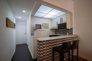 cocina con encimera con 2 sillas y ventana en COPACABANA - Lindo apartamento na quadra da praia, en Río de Janeiro