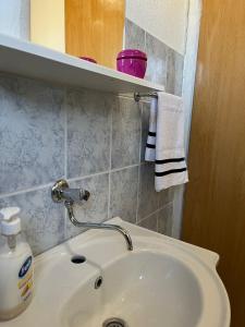 ein Badezimmer mit einem weißen Waschbecken und einem Spiegel in der Unterkunft Kuca za odmor Marija in Kupres