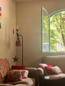 sala de estar con sofá y ventana en Cálida casa en barrio tranquilo cerca de la Laguna en Chascomús