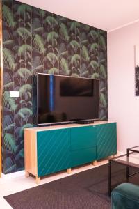 Una sala de estar con un televisor de pantalla plana en una pared. en Apartament na Kaszubach, en Kościerzyna