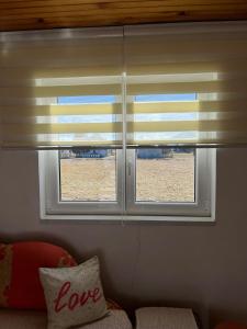 2 ventanas con persianas en la sala de estar en Kuca za odmor Marija en Kupres