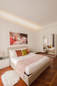 a bedroom with a large bed with a painting on the wall at Pop Corn Vatican Suites in Rome