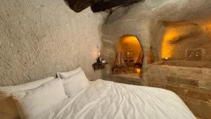 a bedroom with a bed and a tub in a room at crassula cave kapadokya hotel in Nar